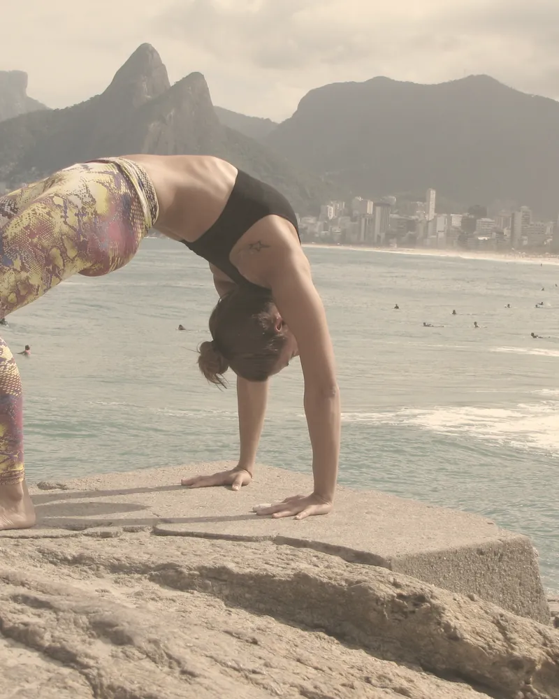 Postura da ponte sobre pedra, com o Morro Dois Irmãos ao fundo.